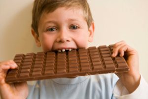 Boy eating large chocolate bar